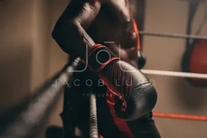 Boxer resting against the ropes of a boxing ring